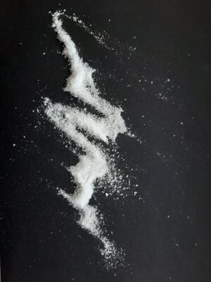 Abstract pattern created with white powder on a black background for artistic effect.
