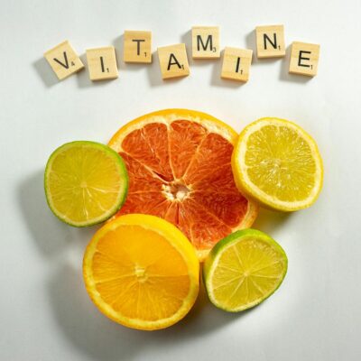 Hücrelerin Koruyucu Kalkanı: E Vitamini Hakkında Kapsamlı Bilgiler Vibrant citrus fruits arranged with scrabble tiles spelling 'VITAMIN E'. Bright and fresh composition.