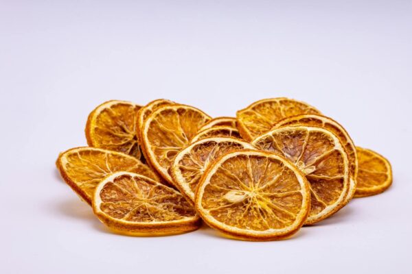 A vibrant close-up of dried orange slices arranged on a white background, perfect for food photography.