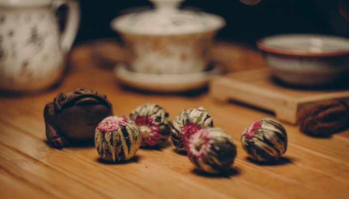 Close-up of a traditional tea setup featuring ceramic cups and blooming flower tea, highlighting an elegant and tranquil atmosphere.