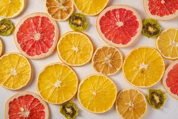 Vibrant arrangement of dried slices of citrus fruits with kiwi on a white background.