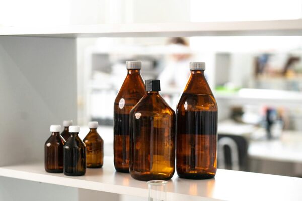 Close-up of brown glass bottles on a shelf in a laboratory environment.
