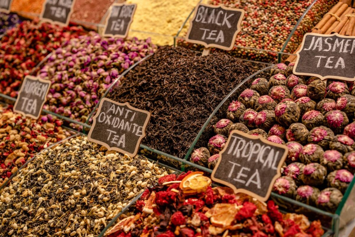 A vibrant display of various teas at a market stall, highlighting diverse flavors and colors.