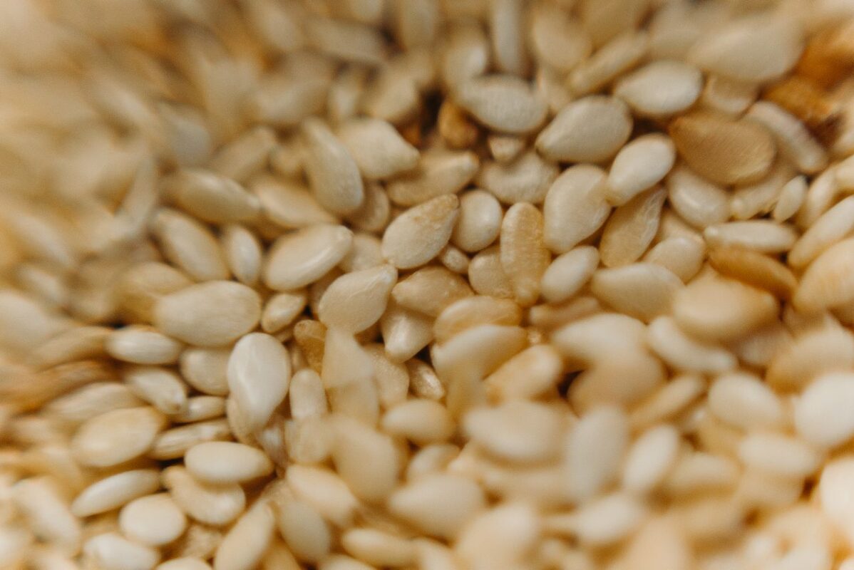 Detailed macro photography of raw sesame seeds capturing texture and earthy tones.