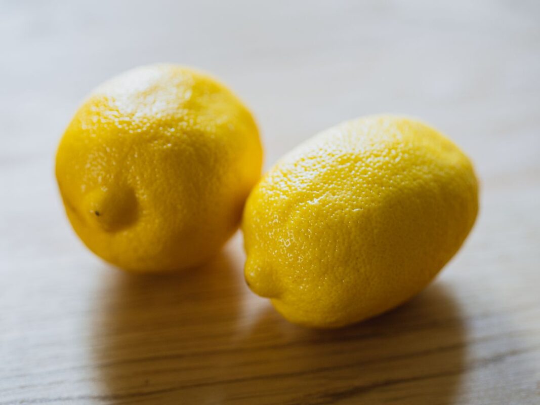 Limon Kabuğu Yağı: Doğadan Gelen Ferahlığın ve Saf İçeriğin Hikayesi Ripe sour whole lemons placed on wooden surface in light room in kitchen with sunlight at home during harvest season